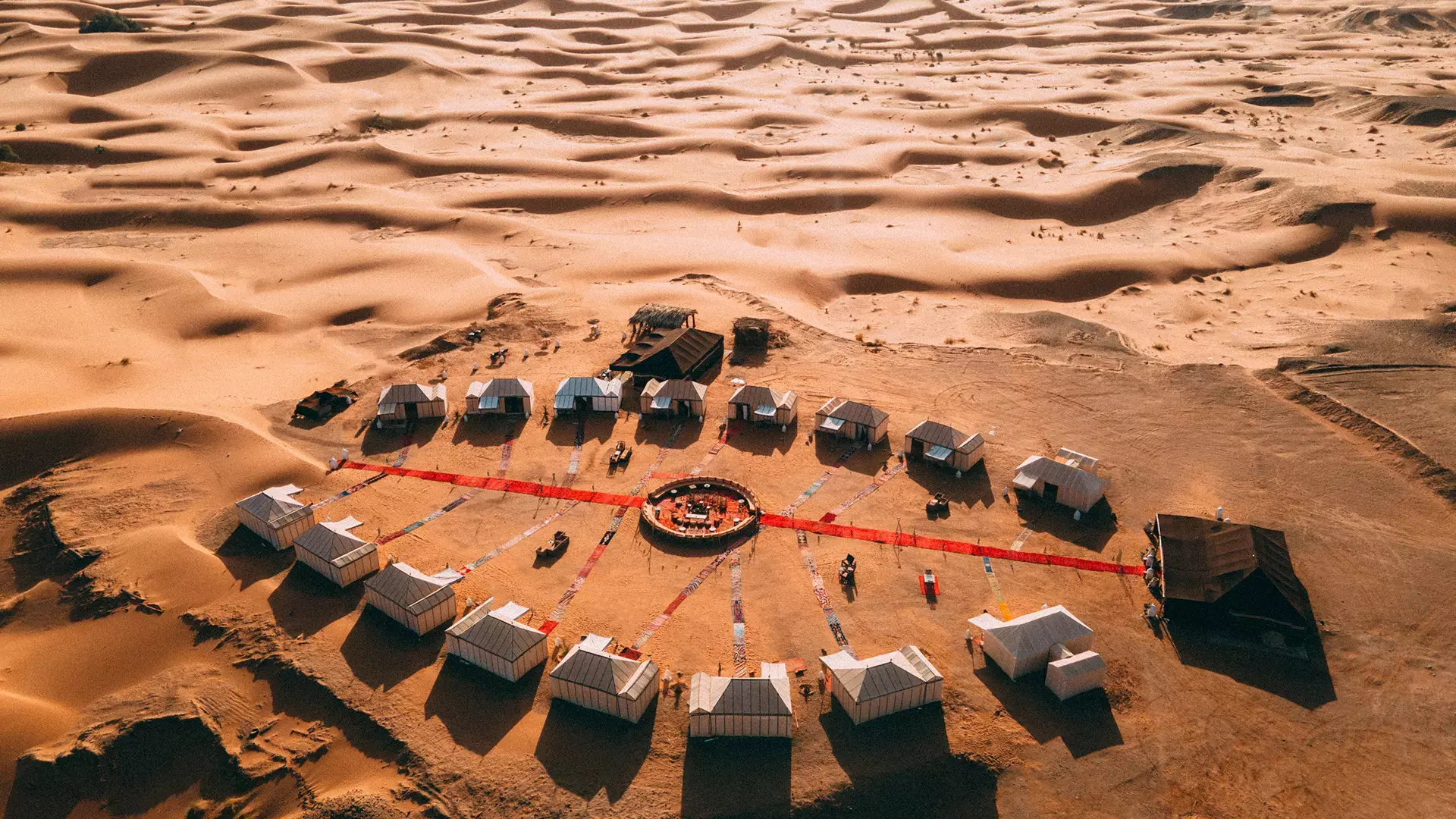Luxurious desert oasis retreat in Erg Chebbi, Sahara Desert, featuring sustainable accommodations surrounded by golden dunes