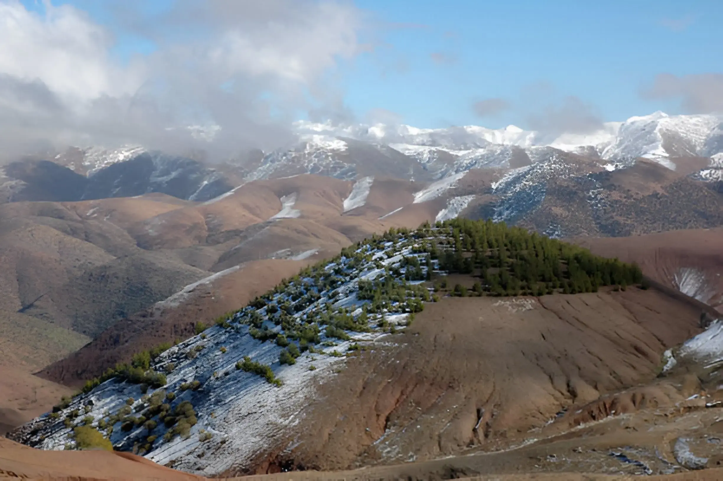 Things to Do in Morocco A scenic view of the rugged peaks and lush valleys of the Atlas Mountains in Morocco.